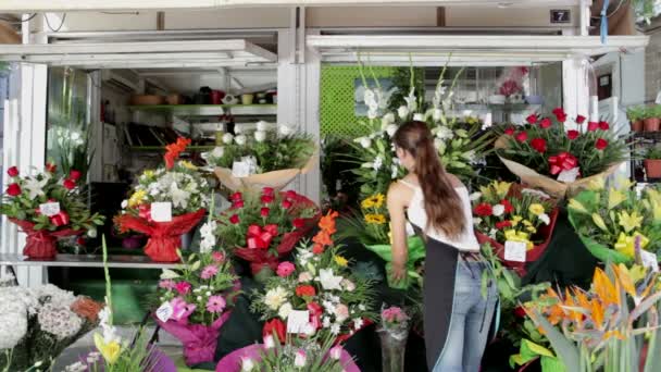 Bloemist die een boeket zonnebloemen ophaalt en vervoert — Stockvideo