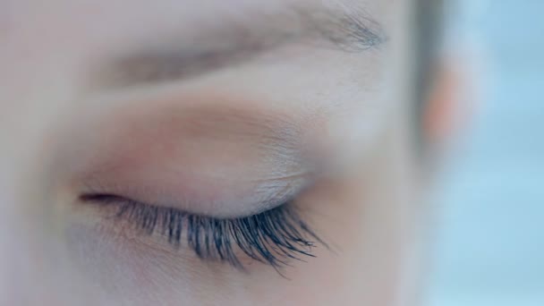 Ojo de mujer mirando a la cámara y parpadeando lentamente — Vídeos de Stock