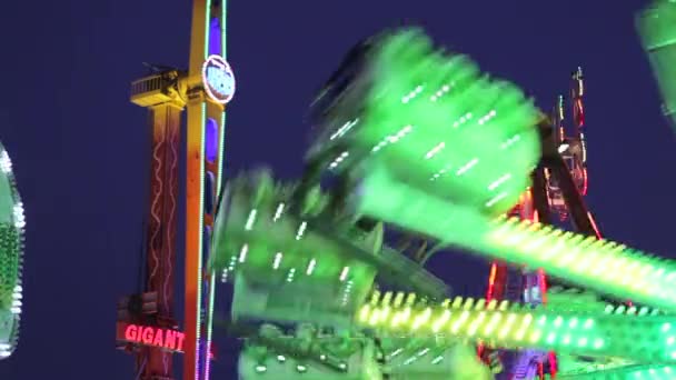 Rides in motion at night in an amusement park — Stock Video