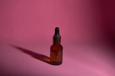 Damlatan cam şişe maketi. Soyut arkaplanda kozmetik pipeti 