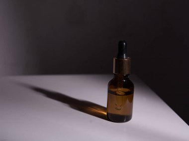 Damlatan cam şişe maketi. Soyut arkaplanda kozmetik pipeti 