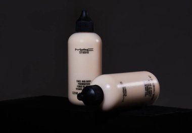 Udachnyy, Rusya, Şubat 05, 2021: MAC Studio yüz ve vücut plastik şişe konteynır koyu bir arka plan üzerine kurulmuştur. Vakıf kremi, kapatıcı, temel, BB kremi reklamı. 
