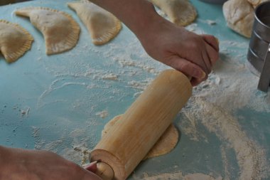 Kadınların elleri merdane, qutab ya da chebureki, kıyma ve soğan yapma sürecinde. Azerbaycan, Tatar, Kafkas, Yunan mutfağı. Latin Amerika 'daki Empanadas