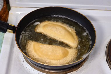 Ev yapımı qutab veya chebureki ile kızartılmış ayçiçeği yağı, kıyma ve soğanlı calzone ile işleniyor. Mutfakta yemek yapma süreci. Azerbaycan, Tatar, Kafkas, Yunan mutfağı. Latin Amerika 'daki Empanadas 