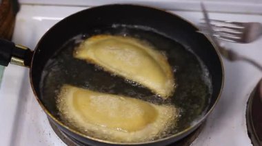 Ev yapımı chebureks, qutab veya calzone ve kıymalı soğan ile kızartılmış ayçiçeği yağı ile işleniyor. Mutfakta yemek yapma süreci. Azerbaycan, Tatar, Kafkas, Yunan mutfağı. Latin Amerika 'daki Empanadas 