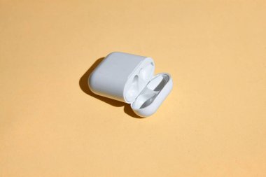 Rusya, Udachnyy, 20 Nisan 2021. Beyaz kablosuz bluetooth kulaklık, kulaklık, plastik kutu veya depolama, şarj ve akıllı telefon için kutu, renk arkaplanı kapat 