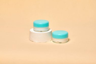 Pastel arka planda kozmetik kabı var. Dünya renkleri, sıfır atık konteynırı. Model konsepti. Minimum kutular ve geometrik podyum. Geometrik şekilli sahne. 