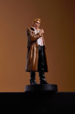 Udachny, Rusya - 27 Ağustos 2021: John Constantine 'in figürü bej bir arkaplan karşısında durmaktadır. Bu, Amerikan çizgi roman yayıncısı DC Comics' in bir baskısı olan Vertigo çizgi romanında yer alan bir süper kahraman.