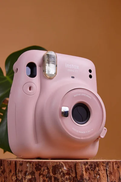 2021年9月19日 俄罗斯Udachnyy 彩色背景上的粉色Fujifilm Instax迷你11即时相机 免版税图库图片