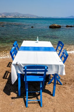 Adada sahil, Rodos, Yunanistan Kolympia şehirde geleneksel Yunan tavernası oturaklı tablolar.