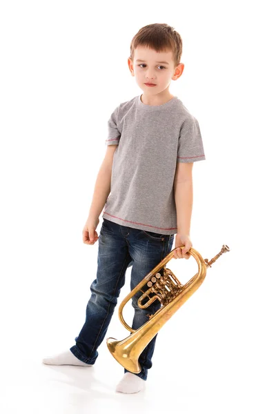 Young boy blowing into a trumpet against white background — Stock Photo, Image