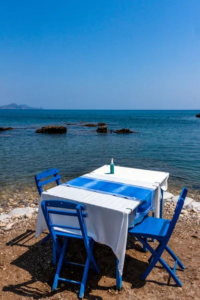 Adada sahil, Rodos, Yunanistan Kolympia şehirde geleneksel Yunan tavernası oturaklı tablolar. — Stok fotoğraf