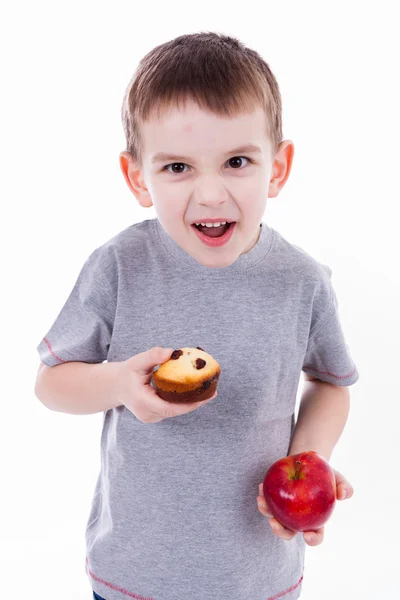 Malý chlapec s jídlem izolovaných na bílém pozadí - apple nebo muffin — Stock fotografie