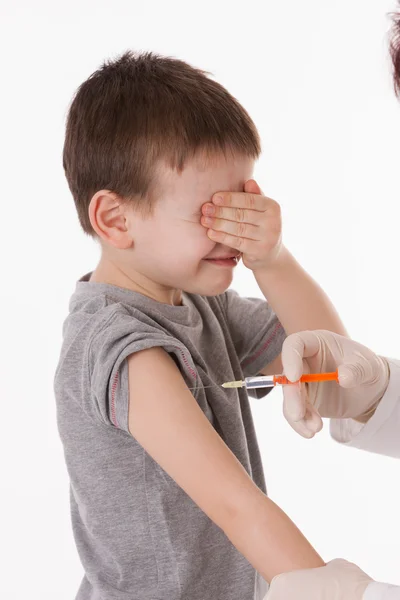 Лікар дає дитині ін'єкції в руку на ізольованому зображенні . — стокове фото