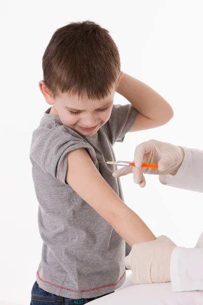 Médico inyectando a un niño en el brazo sobre una imagen aislada . —  Fotos de Stock