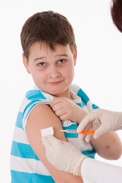 Médico que administra uma injeção de criança no braço — Fotografia de Stock