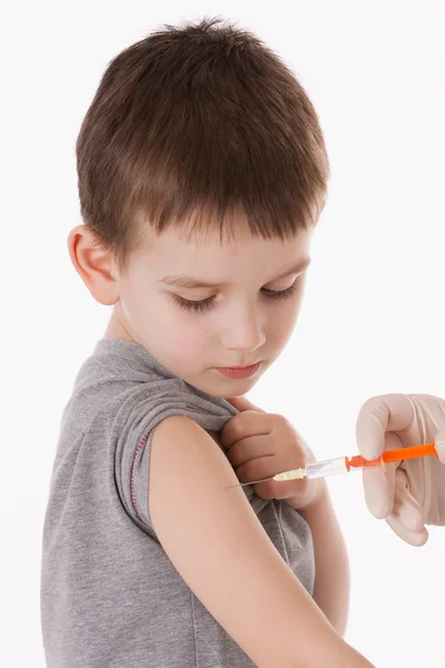 Médico inyectando a un niño en el brazo sobre una imagen aislada . — Foto de Stock