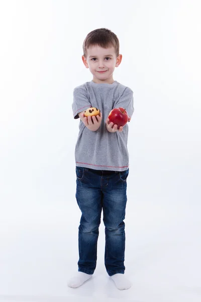 Malý chlapec s jídlem izolovaných na bílém pozadí - apple nebo muffin — Stock fotografie