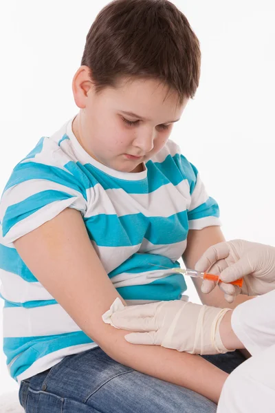 Médico inyectando a un niño en el brazo sobre una imagen aislada . — Foto de Stock