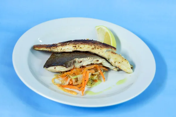 Comida moderna em um prato branco e fundo azul — Fotografia de Stock