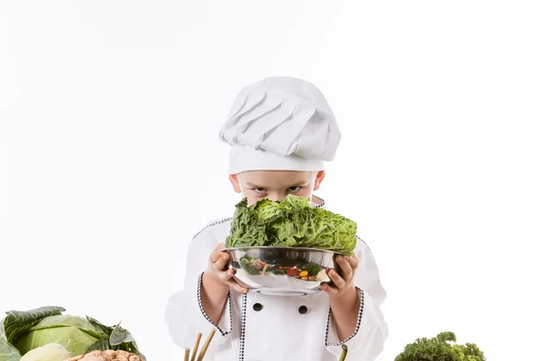 Een kleine jongen als chef kok maken salade, koken met groente — Stockfoto