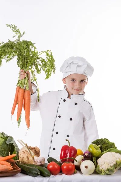 Un niño pequeño como cocinero haciendo ensalada, cocinando con verduras — Foto de Stock