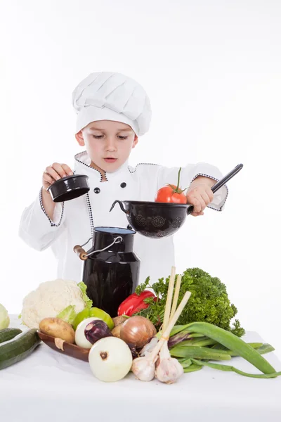 En liten pojke som kock kock att göra sallad, Matlagning med grönsaker — Stockfoto