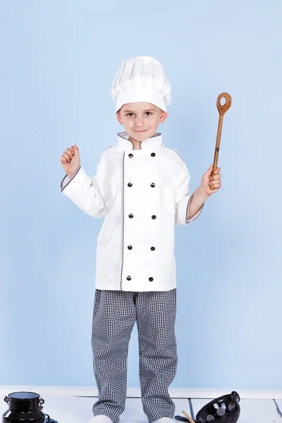 Seorang anak kecil sebagai koki memasak salad, memasak dengan sayuran — Stok Foto
