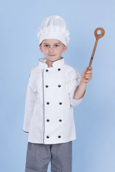 Een kleine jongen als chef kok maken salade, koken met groente — Stockfoto