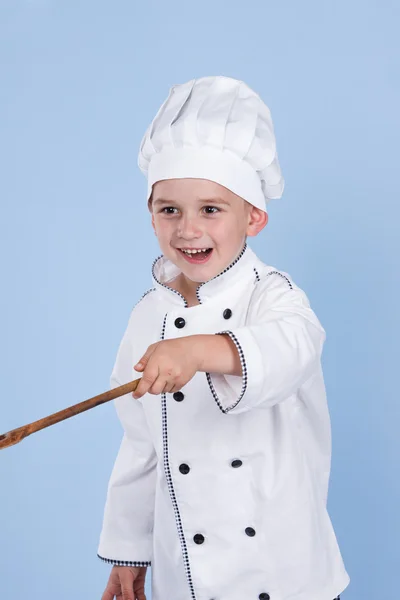 Een kleine jongen als chef kok maken salade, koken met groente — Stockfoto