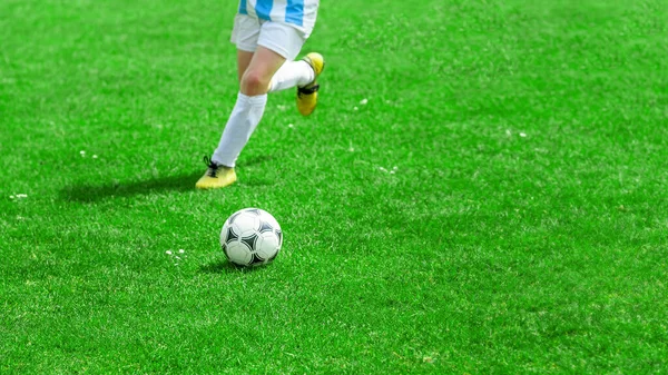 Joueur de football en compétition pour un ballon. Enfants faisant du sport sur terrain herbeux. Image rapprochée du match de football de la jeunesse. — Photo