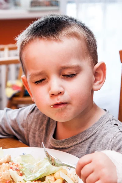 Маленький мальчик за кухонным столом с едой — стоковое фото