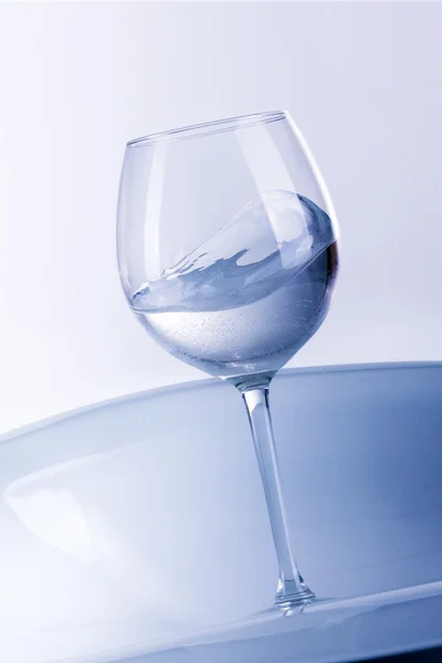 Разбрызгивание воды из стекла на белом фоне — стоковое фото