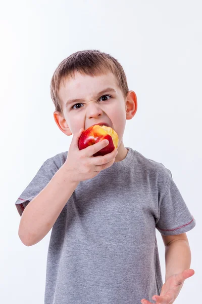 Mały chłopiec z jedzenie na białym tle na białym tle - jabłko lub muffin — Zdjęcie stockowe