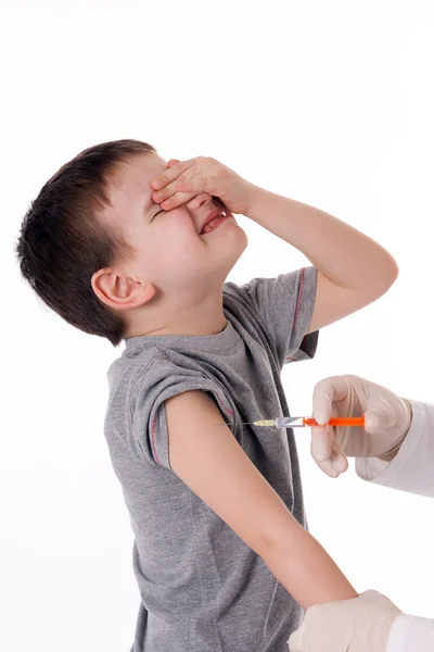 Médico inyectando a un niño en el brazo sobre una imagen aislada . —  Fotos de Stock