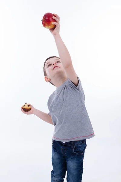 Niño pequeño con comida aislada sobre fondo blanco - manzana o magdalena — Foto de Stock