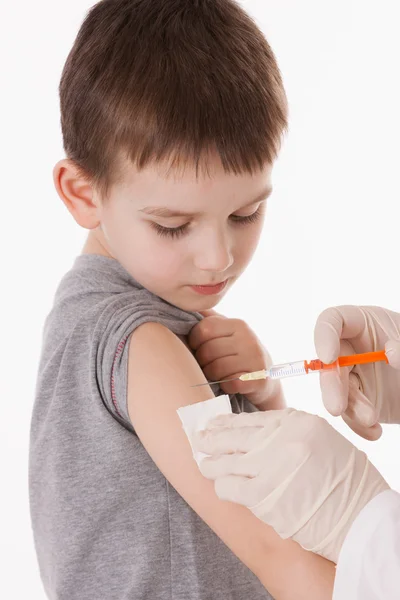 Médico inyectando a un niño en el brazo sobre una imagen aislada . — Foto de Stock