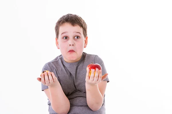 Jongetje met voedsel geïsoleerd op een witte achtergrond - apple of een muffin — Stockfoto