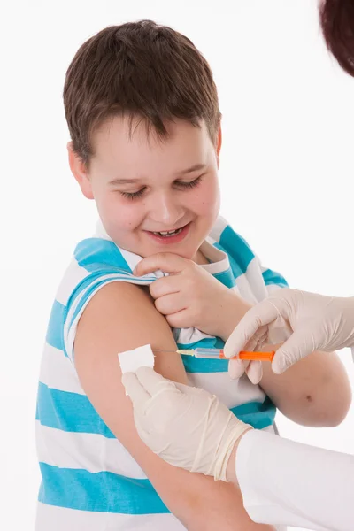 Médico inyectando a un niño en el brazo sobre una imagen aislada . — Foto de Stock