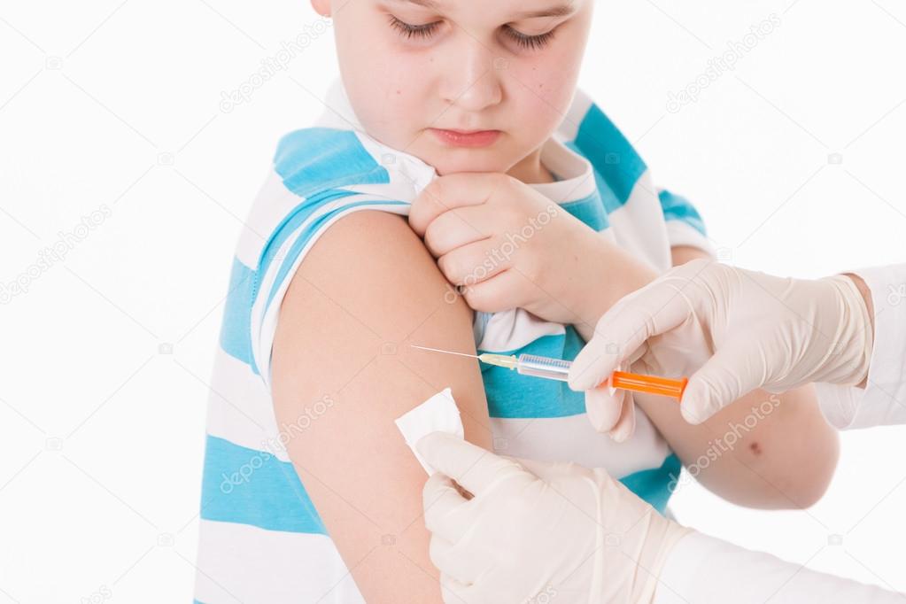Doctor giving a child injection in arm on isolated image.