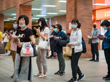 Taipei, Tayvan 'da 14 Mayıs 2021' de cerrahi maske takan yolcular. 3.335.948 kişinin öldüğü doğrulanmış 160.686.749 COVID-19 vakası yaşandı..