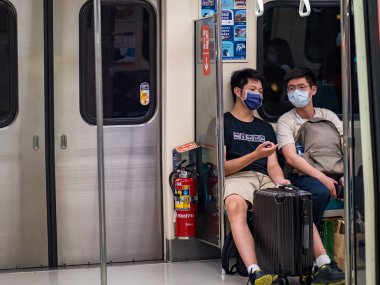 Taipei, Tayvan 'da 14 Mayıs 2021' de cerrahi maske takan yolcular. 3.335.948 kişinin öldüğü doğrulanmış 160.686.749 COVID-19 vakası yaşandı..