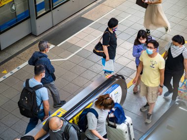 Taipei, Tayvan 'da 14 Mayıs 2021' de cerrahi maske takan yolcular. 3.335.948 kişinin öldüğü doğrulanmış 160.686.749 COVID-19 vakası yaşandı..