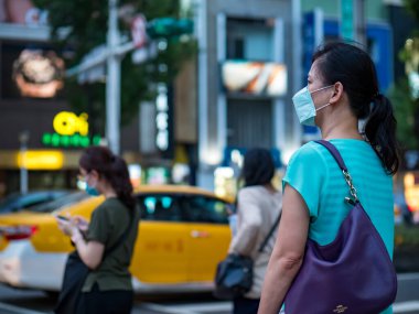 Taipei, Tayvan 'da 14 Mayıs 2021' de cerrahi maske takan yolcular. 3.335.948 kişinin öldüğü doğrulanmış 160.686.749 COVID-19 vakası yaşandı..