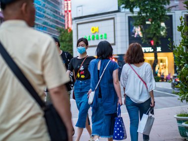 Taipei, Tayvan 'da 14 Mayıs 2021' de cerrahi maske takan yolcular. 3.335.948 kişinin öldüğü doğrulanmış 160.686.749 COVID-19 vakası yaşandı..