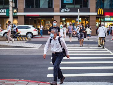 Taipei, Tayvan 'da 14 Mayıs 2021' de cerrahi maske takan yolcular. 3.335.948 kişinin öldüğü doğrulanmış 160.686.749 COVID-19 vakası yaşandı..
