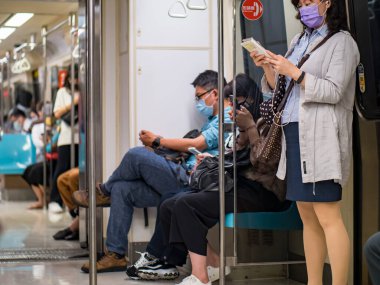 TAIPEI, TAIWAN - 19 Mayıs 2021 tarihinde Tayvan 'ın Taipei kentinde cerrahi maske takan yolcular. 165.096.424 doğrulanmış COVID-19 vakası yaşandı..