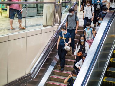 TAIPEI, TAIWAN - 19 Mayıs 2021 tarihinde Tayvan 'ın Taipei kentinde cerrahi maske takan yolcular. 165.096.424 doğrulanmış COVID-19 vakası yaşandı..