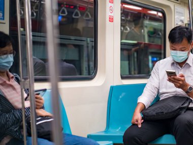 TAIPEI, TAIWAN - 19 Mayıs 2021 tarihinde Tayvan 'ın Taipei kentinde cerrahi maske takan yolcular. 165.096.424 doğrulanmış COVID-19 vakası yaşandı..