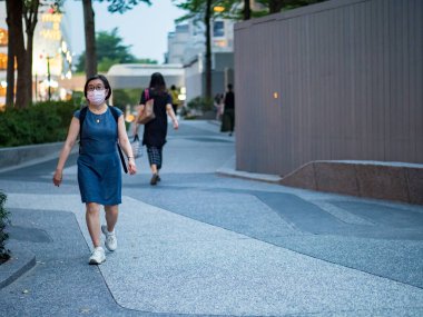 TAIPEI, TAIWAN - 19 Mayıs 2021 tarihinde Tayvan 'ın Taipei kentinde cerrahi maske takan yolcular. 165.096.424 doğrulanmış COVID-19 vakası yaşandı..
